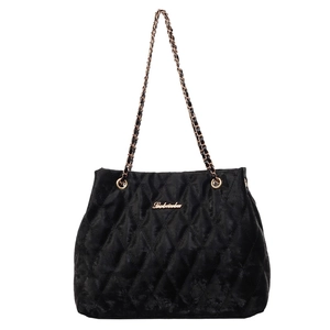 Elegant black velvet quilted tote bag with golden chain strap and minimalist metal logo