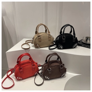 Detail of multi-color vintage woolen cylinder mini bags with silver studs and straps