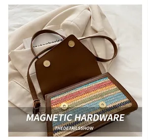 Detail of multi-color woven crossbody bag with brown leather flap and metal magnetic snaps