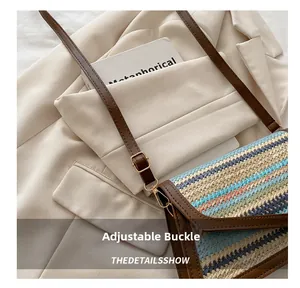 Close-up of colorful straw woven crossbody bag with adjustable gold buckle on blazer