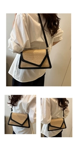 Detail of straw woven envelope crossbody bag with black leather trim and gold hardware
