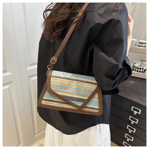 Detail of colorful woven shoulder bag with brown leather trim and adjustable strap