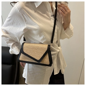 Detail of rainbow straw square bag with black faux leather trim and v-shaped flap