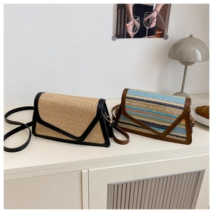 Detail of woven straw envelope bags with leather trim in solid and striped patterns