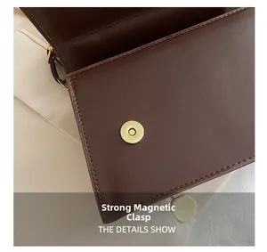 Détail de la fermeture magnétique d'un sac à bandoulière en cuir texturé marron café