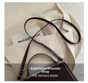 Détail du sac en cuir marron foncé montrant la bandoulière réglable et boucle dorée