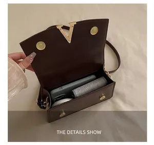 Vue intérieure du sac bandoulière en cuir marron foncé montrant la capacité du sac
