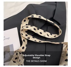 Détail de la bandoulière réglable à pois sur un sac bandoulière beige chic