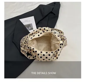 Gros plan sur l'intérieur spacieux avec doublure en satin et fermeture éclair du sac à pois