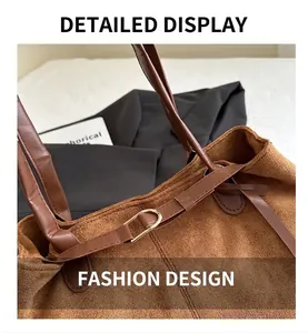 Detail of brown suede shoulder bag with smooth leather strap and golden metal D-ring buckle