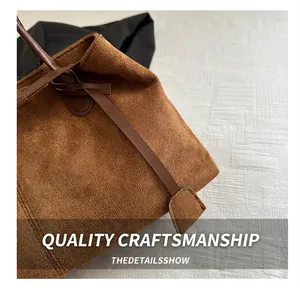 Detailed view of brown suede tote bag featuring premium leather straps and fine stitching