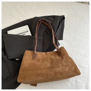 Detailed texture of the dark brown suede tote bag with durable lychee grain leather handles