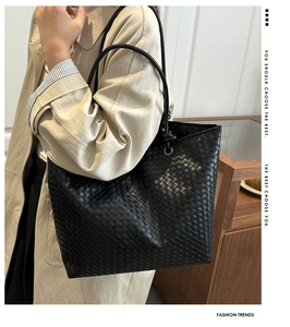 Macro shot of high-quality black woven leather texture on a large tote shoulder bag