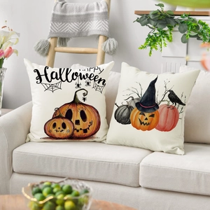 Zwei Halloween-Leinenkissenbezüge mit Kürbis- und Hexenhut-Dekor auf einem Sofa
