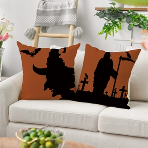 Close-up of Halloween linen pillowcases with witch and bat patterns on a white sofa