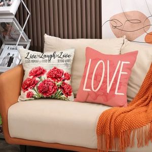 Floral Mother's Day throw pillows with carnations and Love typography on a sofa