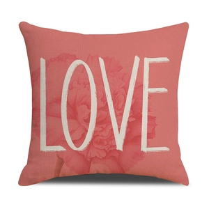Detail of coral linen pillowcase featuring a pink carnation and white LOVE typography