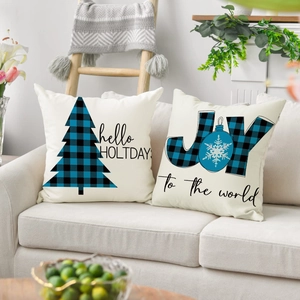 Close-up of linen Christmas pillows with joy and holiday prints on a beige sofa