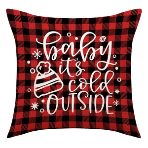 Détail de la housse de coussin à carreaux rouges avec texte Baby it's cold OUTSIDE