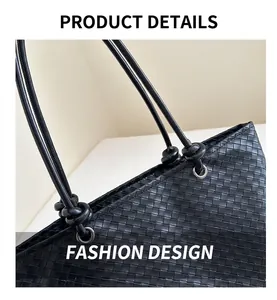 Detail of black woven leather tote with intricate knot handle and metallic eyelet