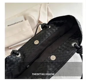 Detail shot of the woven tote bag interior featuring magnetic buckles and a zipper pocket