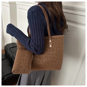 Detail of leopard print tote bag with gold rivets and matching small pouch