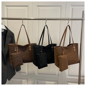 Detail of leopard print tote bags in dark brown, black, and tan with matching coin purses