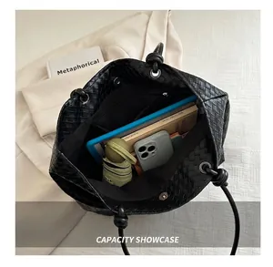 Macro view showing large capacity of black woven tote bag with books and daily items