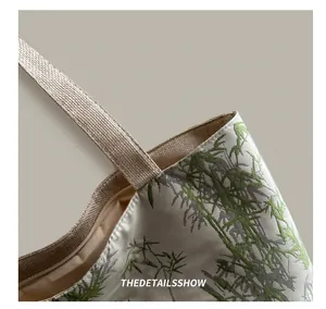 Close-up of bamboo print tote with reinforced woven handles and metal zipper closure