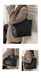 Detail of a black woven leather tote bag with Intrecciato pattern and long slim handles
