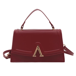 Classic burgundy trapezoid handbag with gold V-hardware and versatile crossbody strap