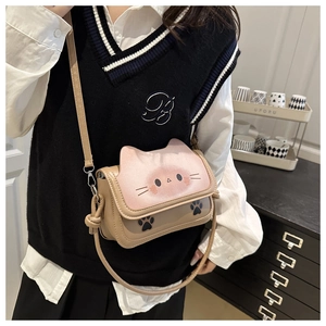 Close-up of cute cat-shaped crossbody bag with pink flap and paw print details