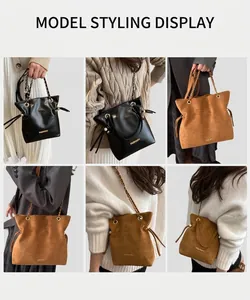 Detail view of suede bucket bag with chain strap and fashion metal logo lettering