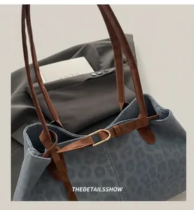 Détail du sac cabas à imprimé léopard bleu avec bandoulière en cuir brun et boucle dorée