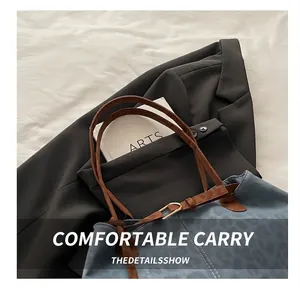 Détail d'un cabas léopard avec poignée en cuir marron et surpiqûres blanches