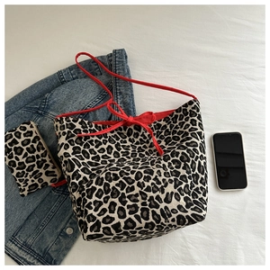 Close-up of leopard print canvas tote bag with red drawstring and matching small pouch