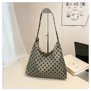 Close-up of khaki green polka dot hobo bag with adjustable strap on display stand