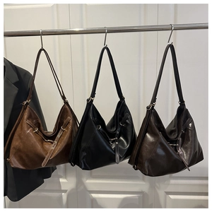 Three vintage faux leather tote bags in brown, black and coffee hanging on a rack