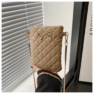 Detail of khaki quilted crossbody bag featuring a golden bow and elegant chain strap