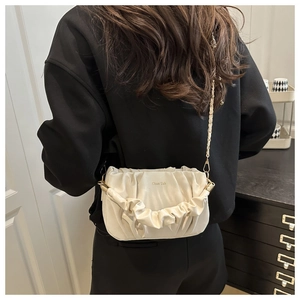 Détail du sac nuage plissé crème avec bandoulière chaîne dorée et logo embossé