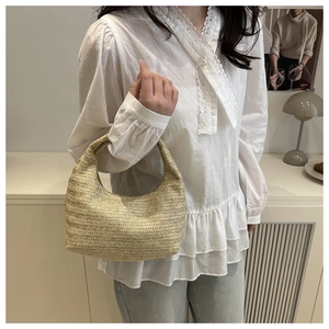 Détail du sac hobo en paille tressée à la main montrant la texture naturelle des fibres