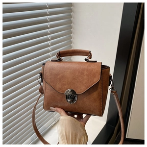 Détail du sac à main vintage marron en similicuir avec boucle en métal et poignée