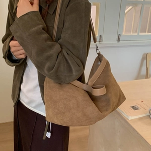 Close-up of caramel brown suede tote bag with leather straps for autumn fashion style
