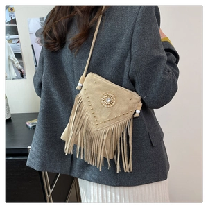 Detail view of khaki suede fringe crossbody bag with metal studs and bohemian style