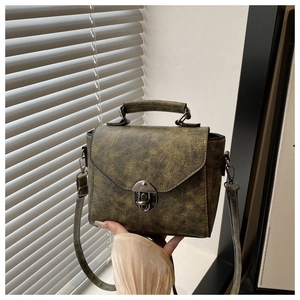 Détail du sac bandoulière vintage en cuir mat avec boucle en métal et poignée haute