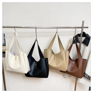 Detail of minimalist hobo tote bags in white, black, beige, and brown with metal buckles
