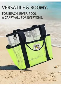 Close-up of neon green mesh beach bag with black handles on a sunny sandy seaside