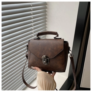 Détails du sac vintage marron foncé avec fermoir en bronze et bandoulière réglable