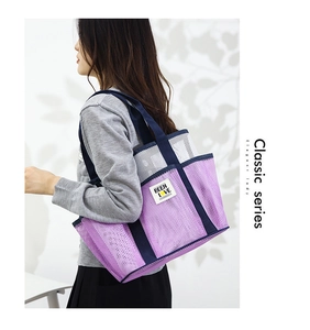 Detail of a purple mesh beach tote bag featuring breathable nylon and sturdy navy shoulder straps