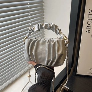 Sac à main nuage argenté plissé avec bandoulière chaîne tenu par une personne